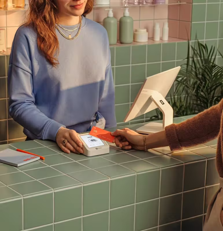 Boutique salon counter with branded POS terminal on mint tile